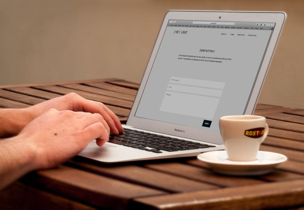 Επαγγελματίας ανανεώνει WordPress site από laptop με καφέ
